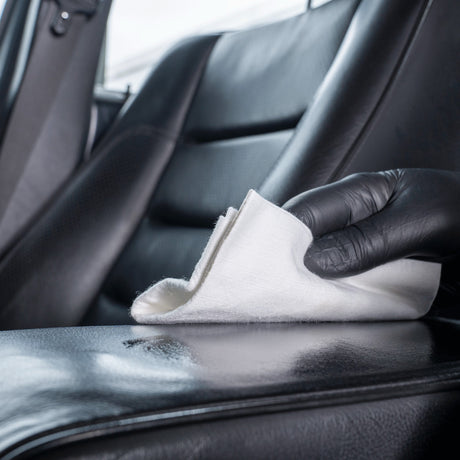 Detailing1 COLOURLOCK Leather Care — leerverzorging met een doek over de zwarte armsteun verdelen